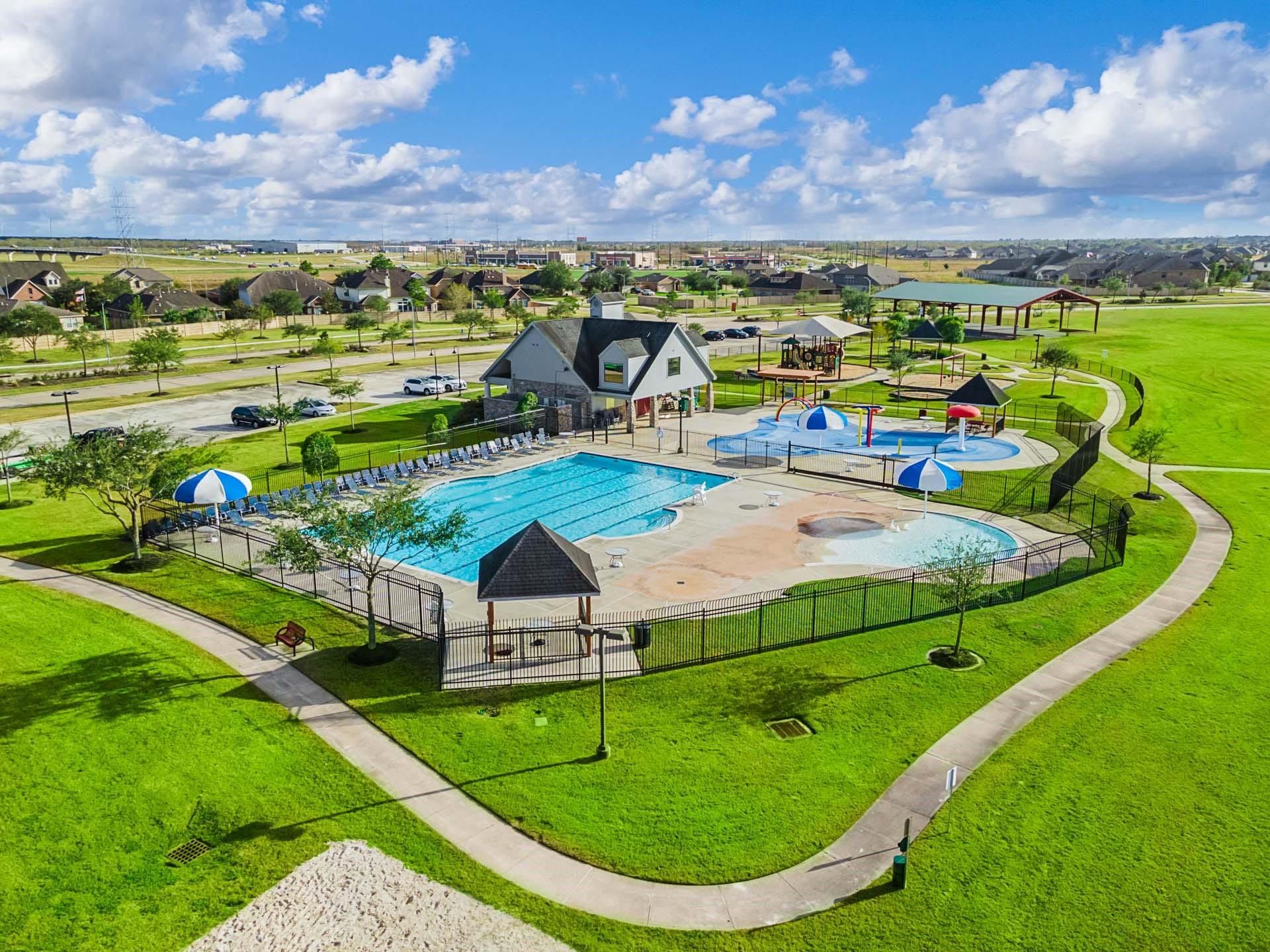 Aerial view of the community swimming pool, splash pad, and playground at Sierra Vista in Rosharon, Texas.