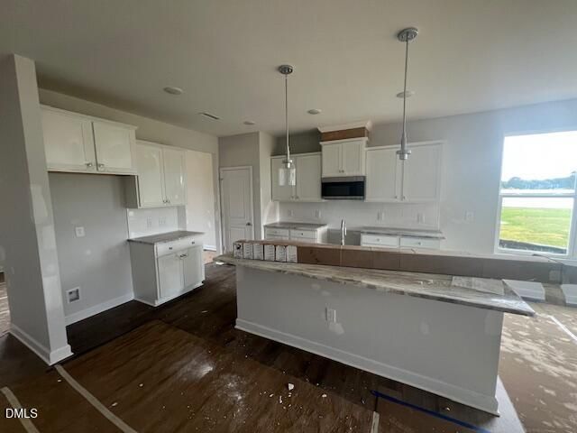 Modern kitchen with white cabinets and island in The Ash B floor plan at Retreat at North Main, Lillington, NC.