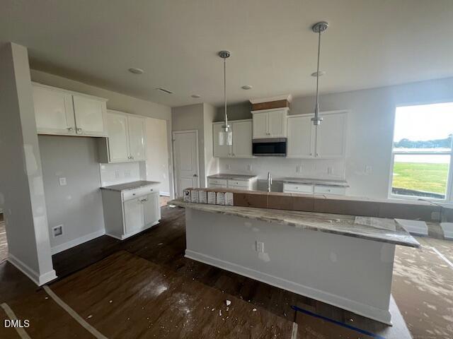 Modern kitchen with white cabinets and island in The Ash B floor plan at Retreat at North Main, Lillington, NC.