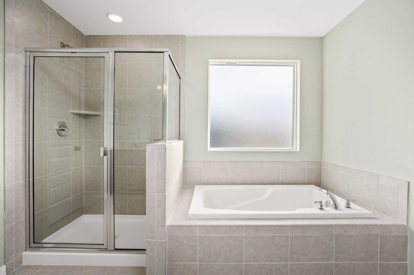 Modern master bathroom featuring glass-enclosed shower and soaking tub in Davidson Homes The Gordon B, White House, TN