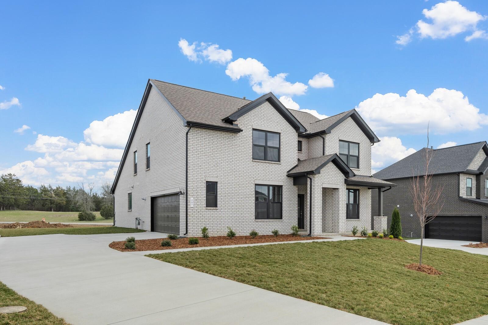 Modern two-story brick home with black-trimmed windows, 2-car garage, driveway, and landscaped yard in Benders Cove, Mt. Juliet, Tennessee