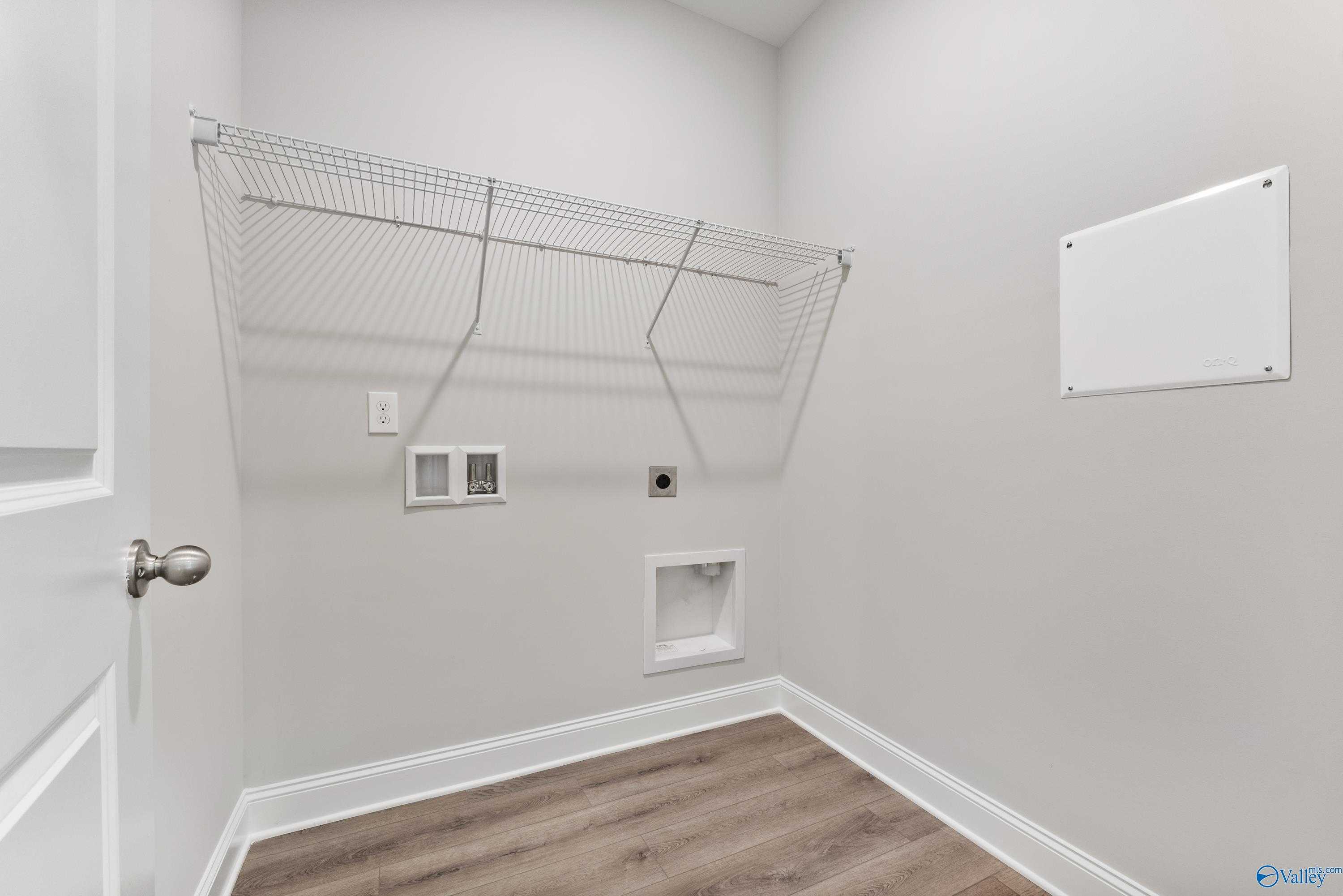 Spacious laundry room with wire shelving, washer dryer hookups, and light gray walls in The Franklin C, Toney, Alabama