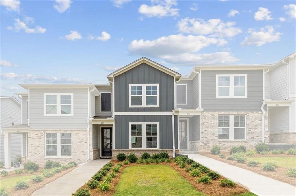 Modern 2-story gray townhome with brick accents, large windows, and landscaped front yard in Stegall Village, Emerson, Georgia