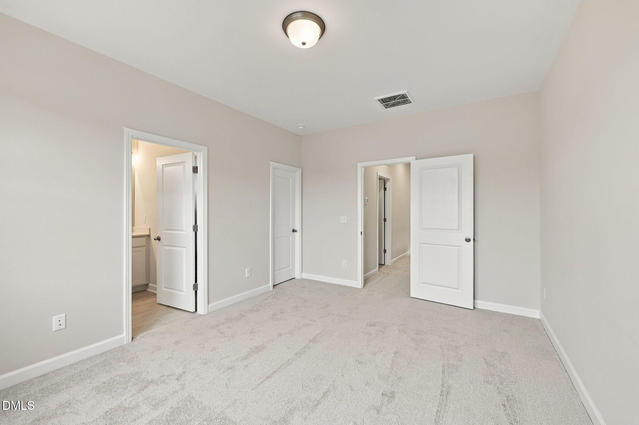 Spacious carpeted bedroom with white doors and neutral walls in Davidson Homes The Alexander B plan, Knightdale, NC