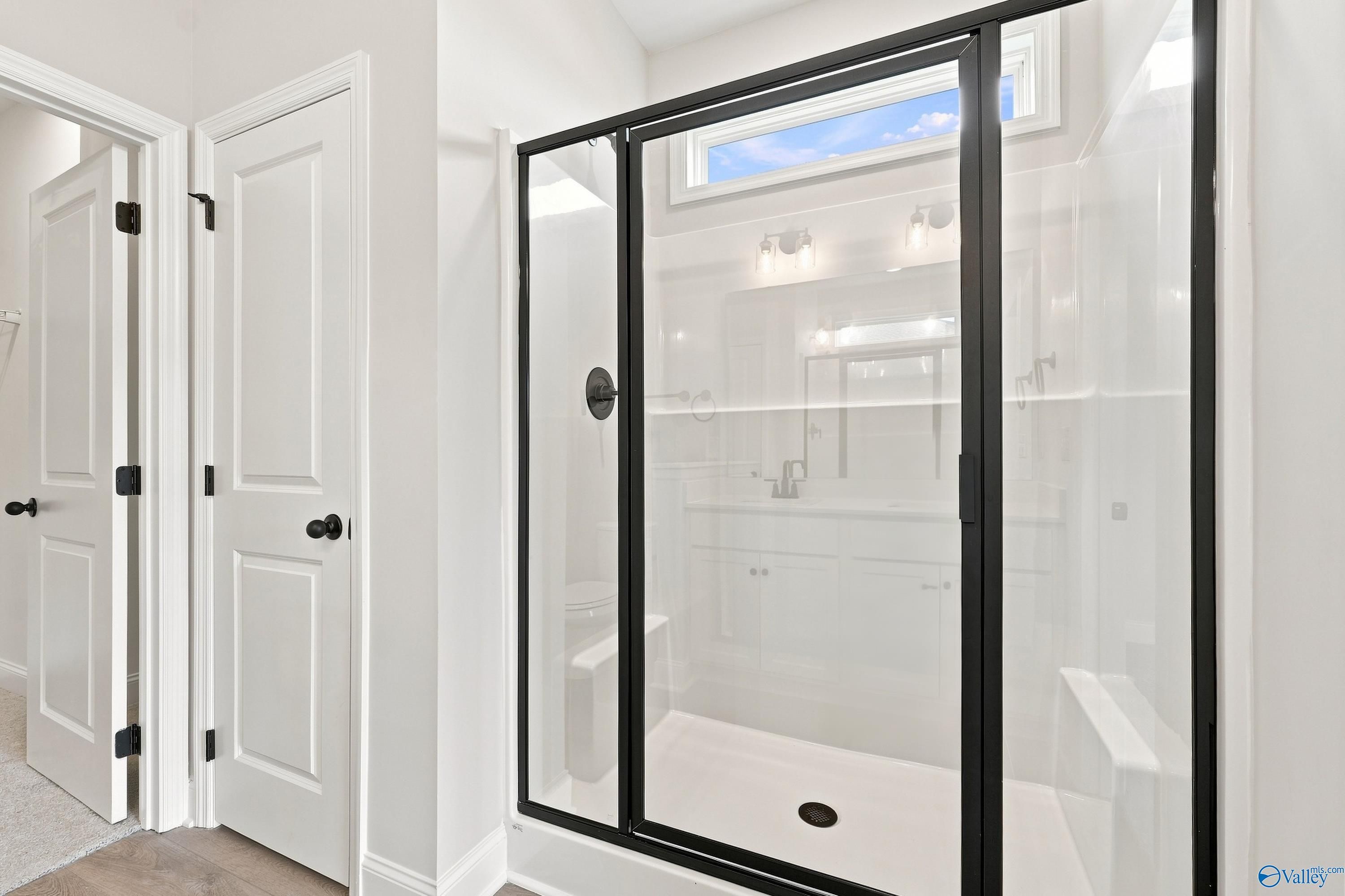 Modern walk-in shower with black frame in the Asheville E floor plan at Forest Glen, Hazel Green, Alabama.