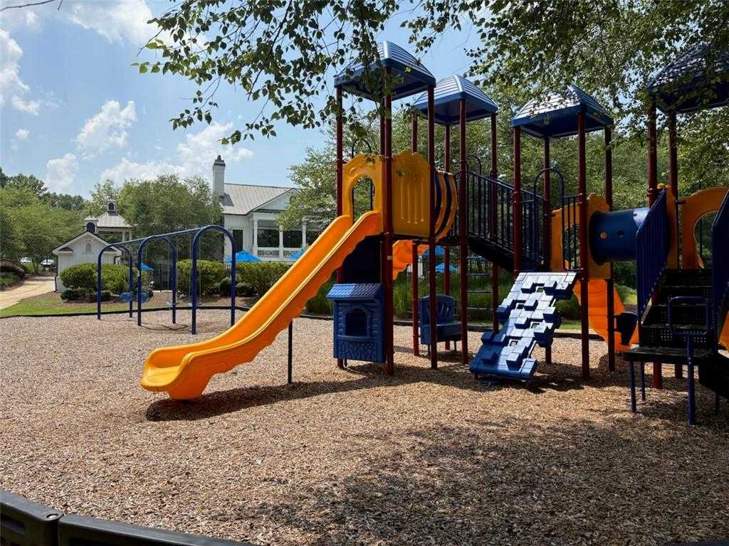 Vibrant playground with orange slide, blue climbing towers, and swings in Riverwood, Dallas, Georgia community near Davidson Homes