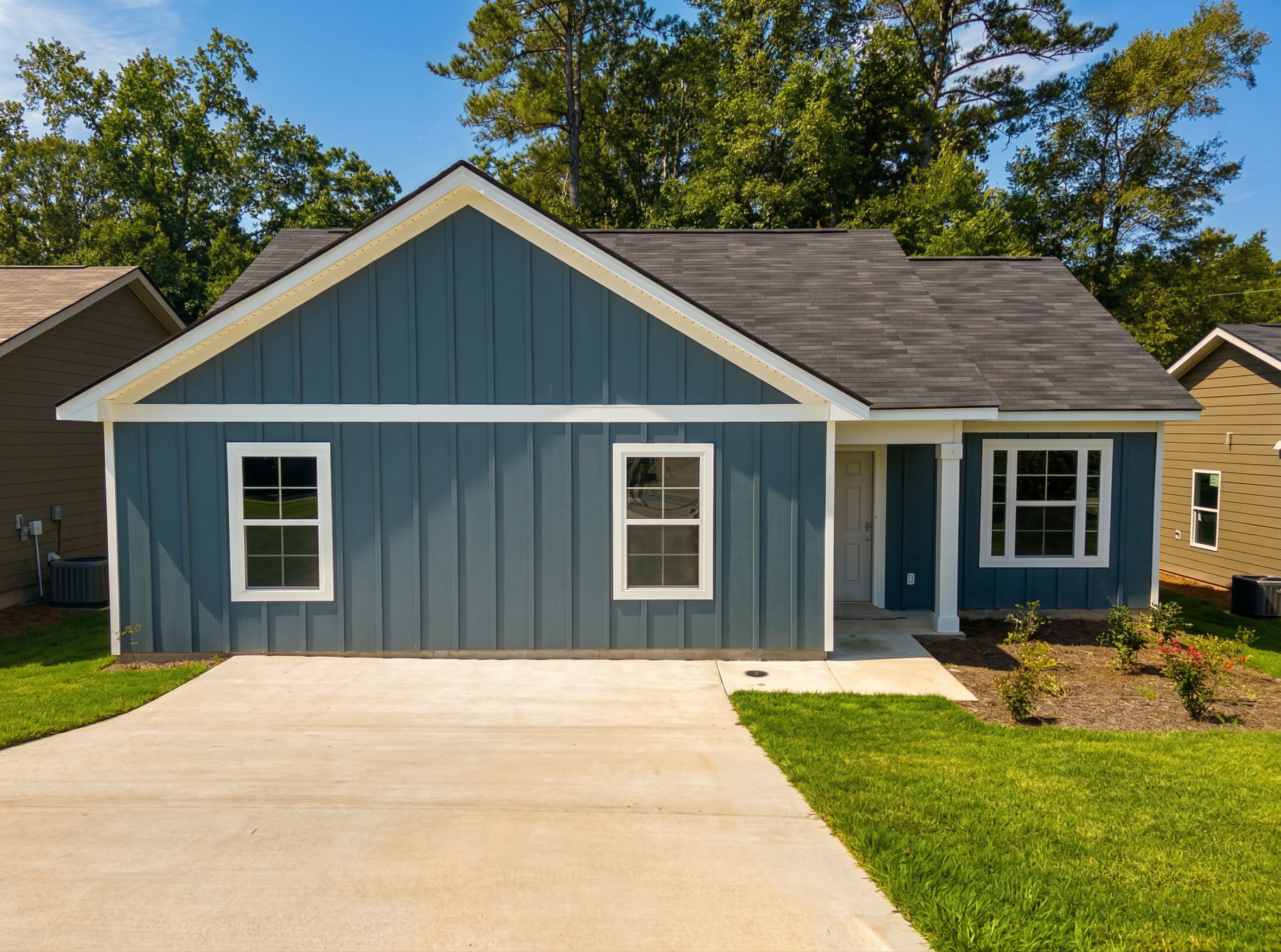 Navy blue Craftsman home exterior in Summer Vineyard, Phenix City AL with covered porch, driveway and lush green yard