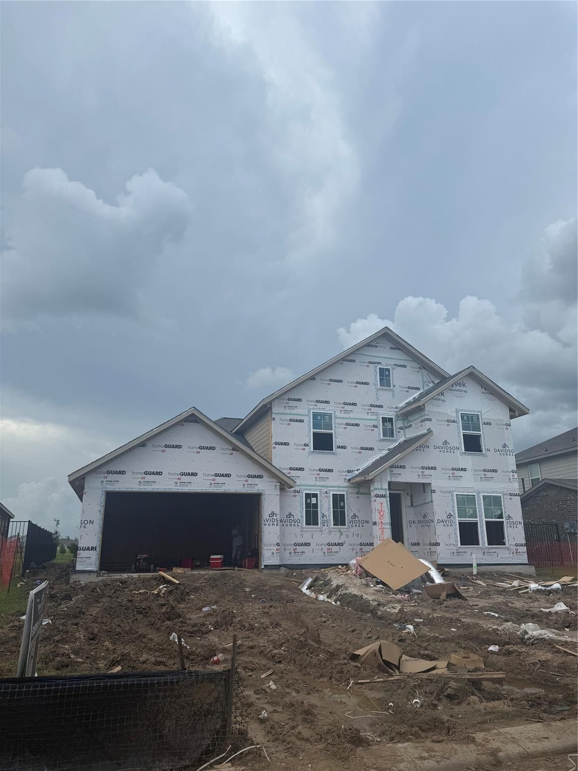 Two-story 4-bed home under construction with 2-car garage, white sheathing, and gabled roof in Sierra Vista, Rosharon, Texas – Davidson Homes The Philip B