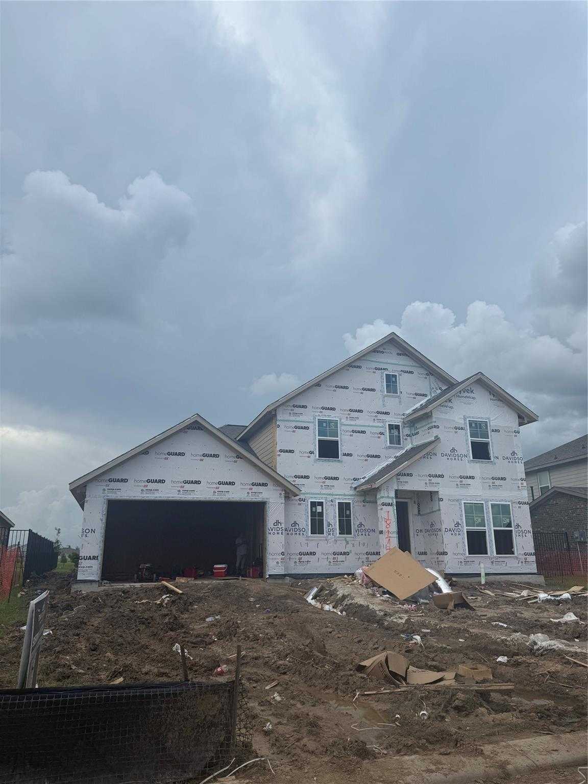 Two-story 4-bed home under construction with 2-car garage, white sheathing, and gabled roof in Sierra Vista, Rosharon, Texas – Davidson Homes The Philip B