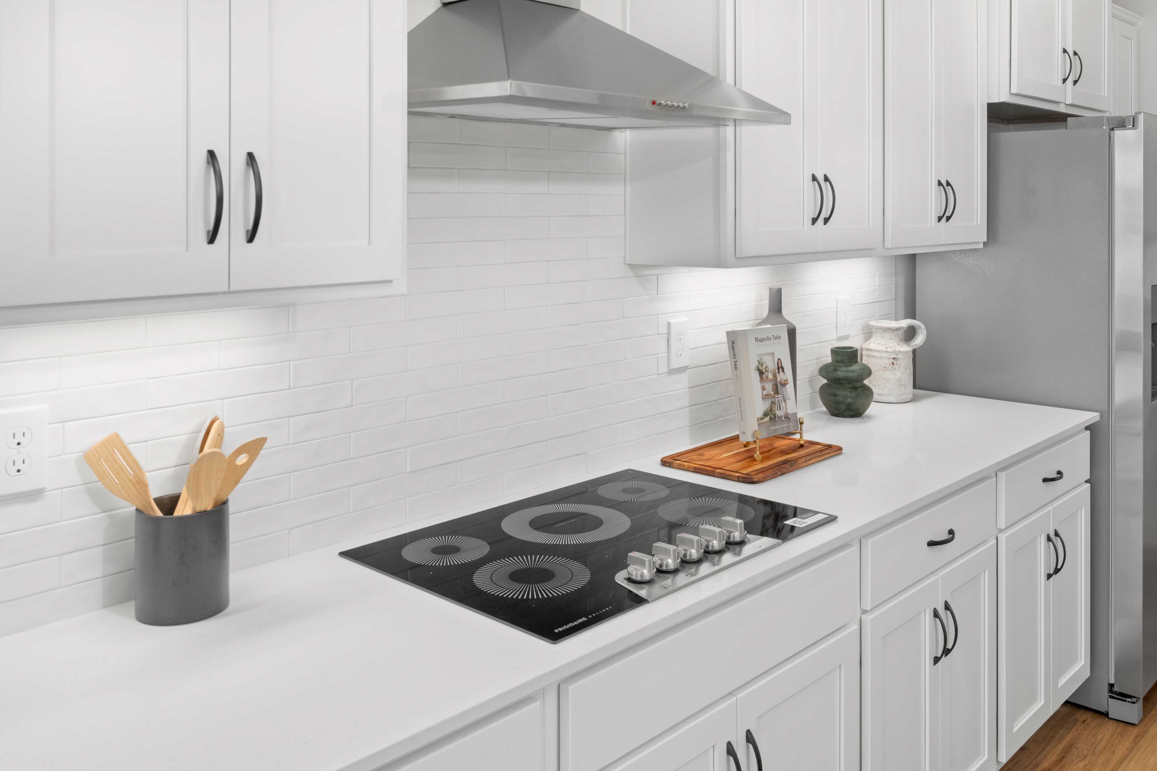 Spacious white kitchen in Briercreek Meridianville AL with induction cooktop subway tile backsplash stainless hood