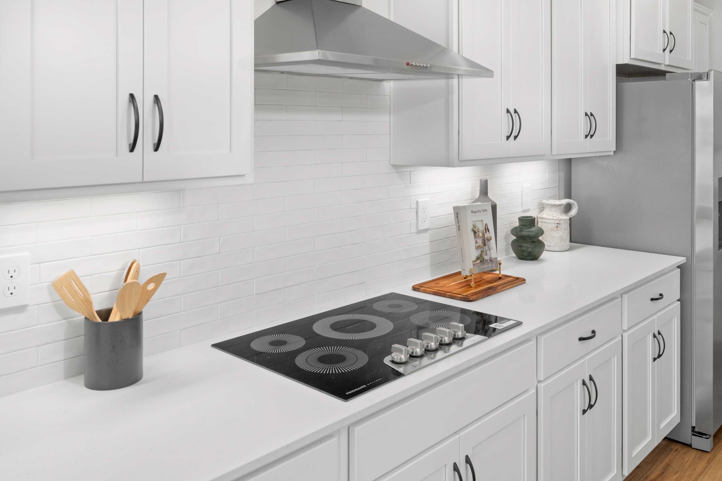 Spacious white kitchen in Briercreek Meridianville AL with induction cooktop subway tile backsplash stainless hood
