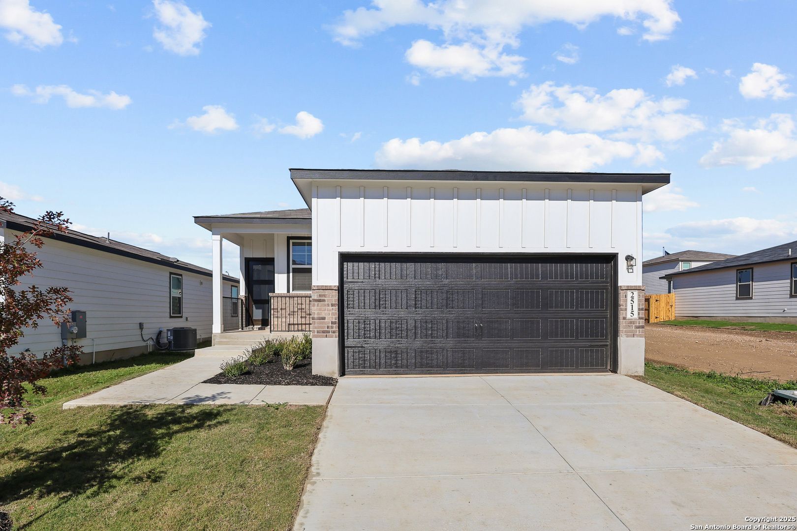Modern white single-story 4-bedroom home with 2-car garage, brick accents, and front porch in Applewhite Meadows, San Antonio, Texas