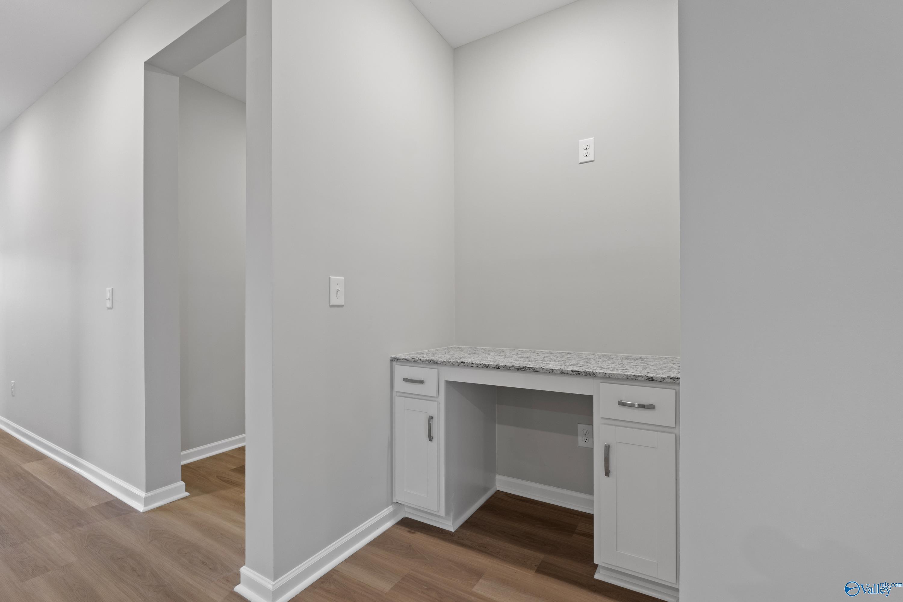 Built-in white desk with granite countertop in light gray hallway of Davidson Homes The Phoenix, Fayetteville, TN
