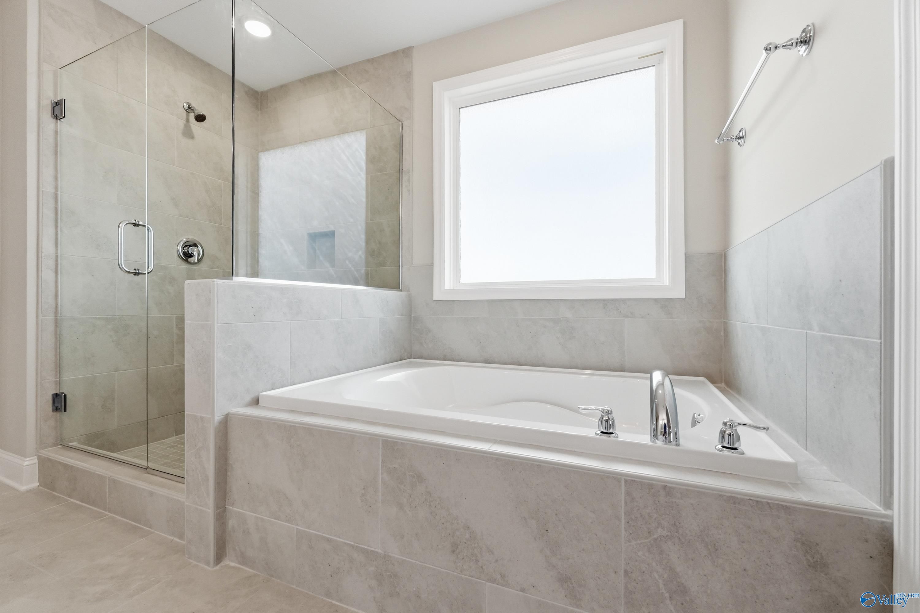 Elegant master bathroom with frameless glass shower and soaking tub in Davidson Homes The Madison A, Meridianville, Alabama