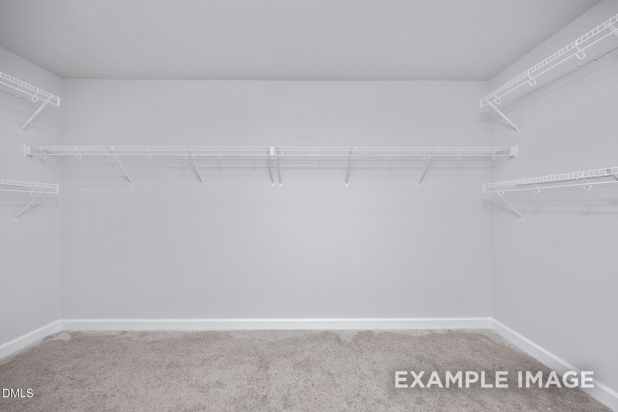 Spacious walk-in closet with white wire shelving and gray carpet in Davidson Homes The Hickory II B, Lillington, NC