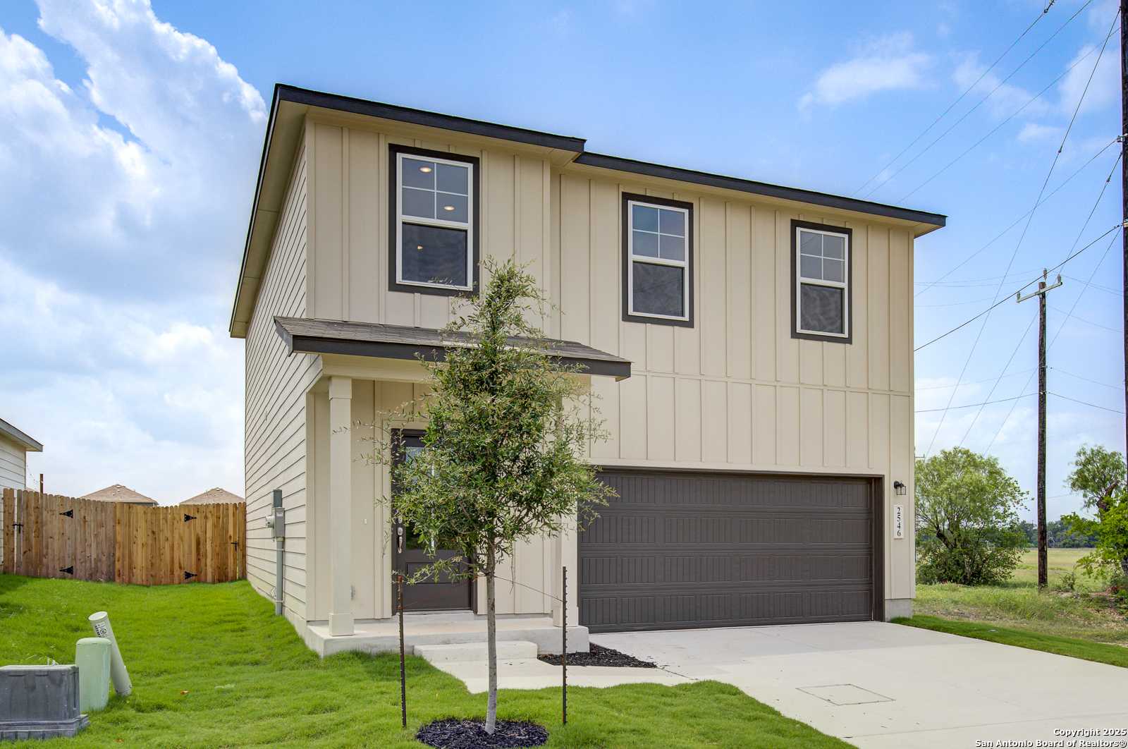 Modern two-story 4-bedroom home with beige siding, two-car garage, and front porch in Applewhite Meadows, San Antonio, Texas by Davidson Homes