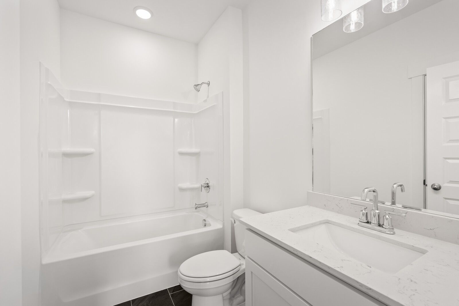 Modern white bathroom with tub-shower combo, quartz vanity, and subway tile in The Willow D, Mt. Juliet, TN
