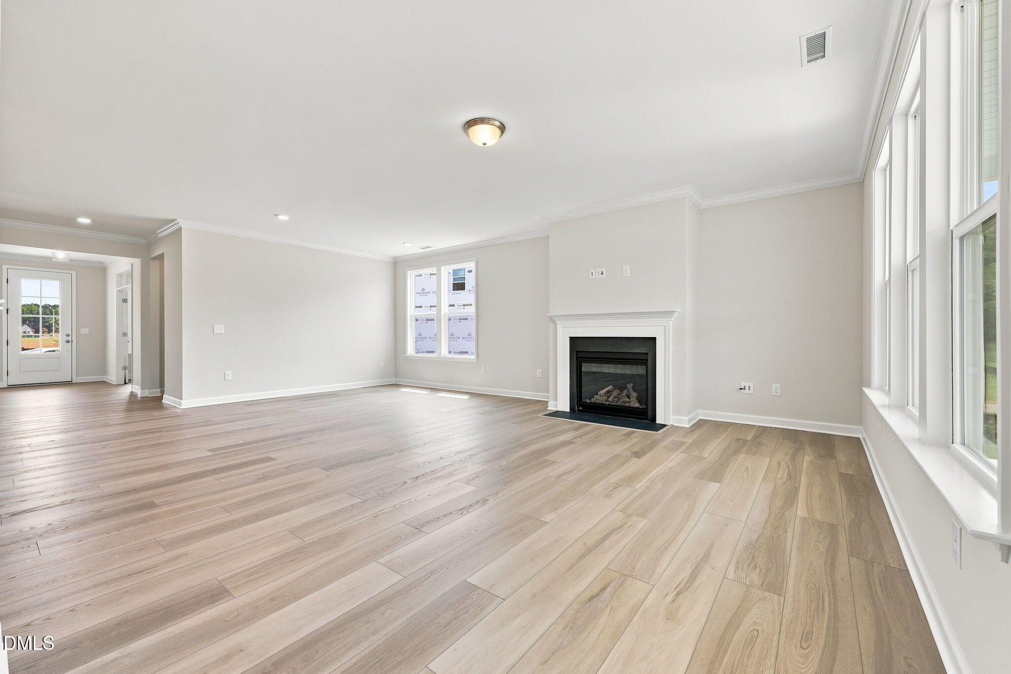 Spacious living room with fireplace and wood-look flooring in The Magnolia B floor plan at Retreat at North Main, Lillington.