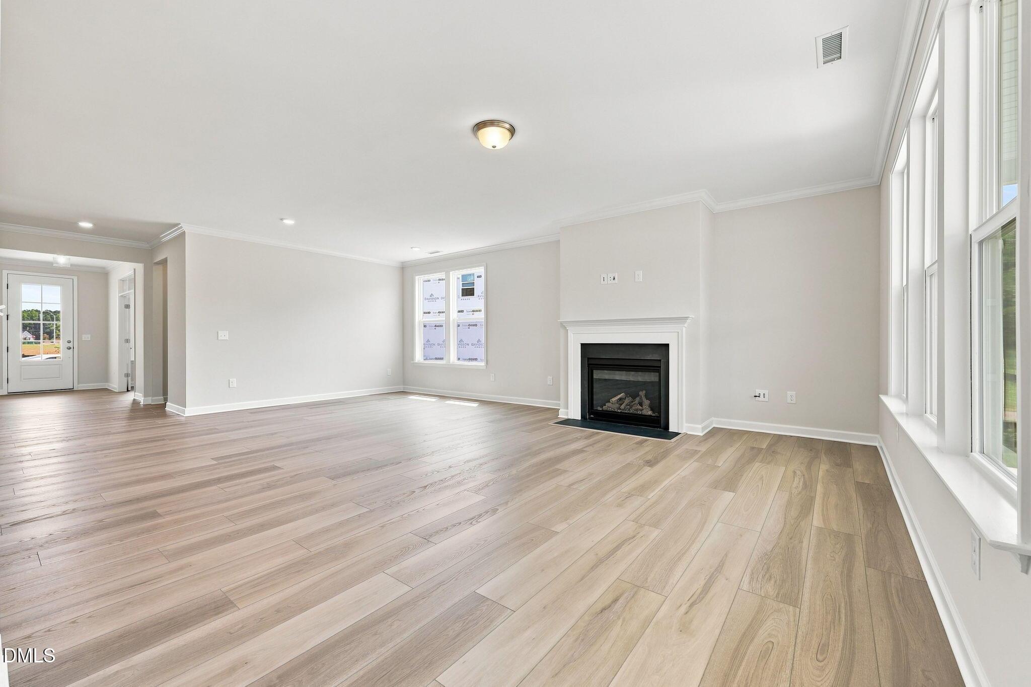 Spacious living room with fireplace and wood-look flooring in The Magnolia B floor plan at Retreat at North Main, Lillington.