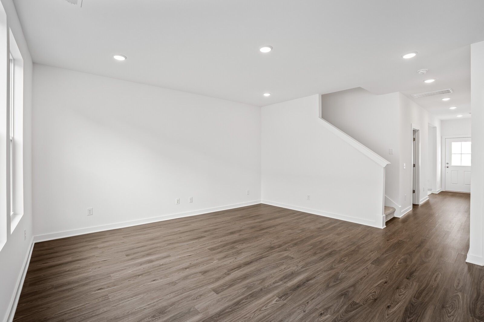 Spacious foyer with hardwood floors, white walls, open staircase in 2-story The Logan C home, Davidson Homes, White House, TN