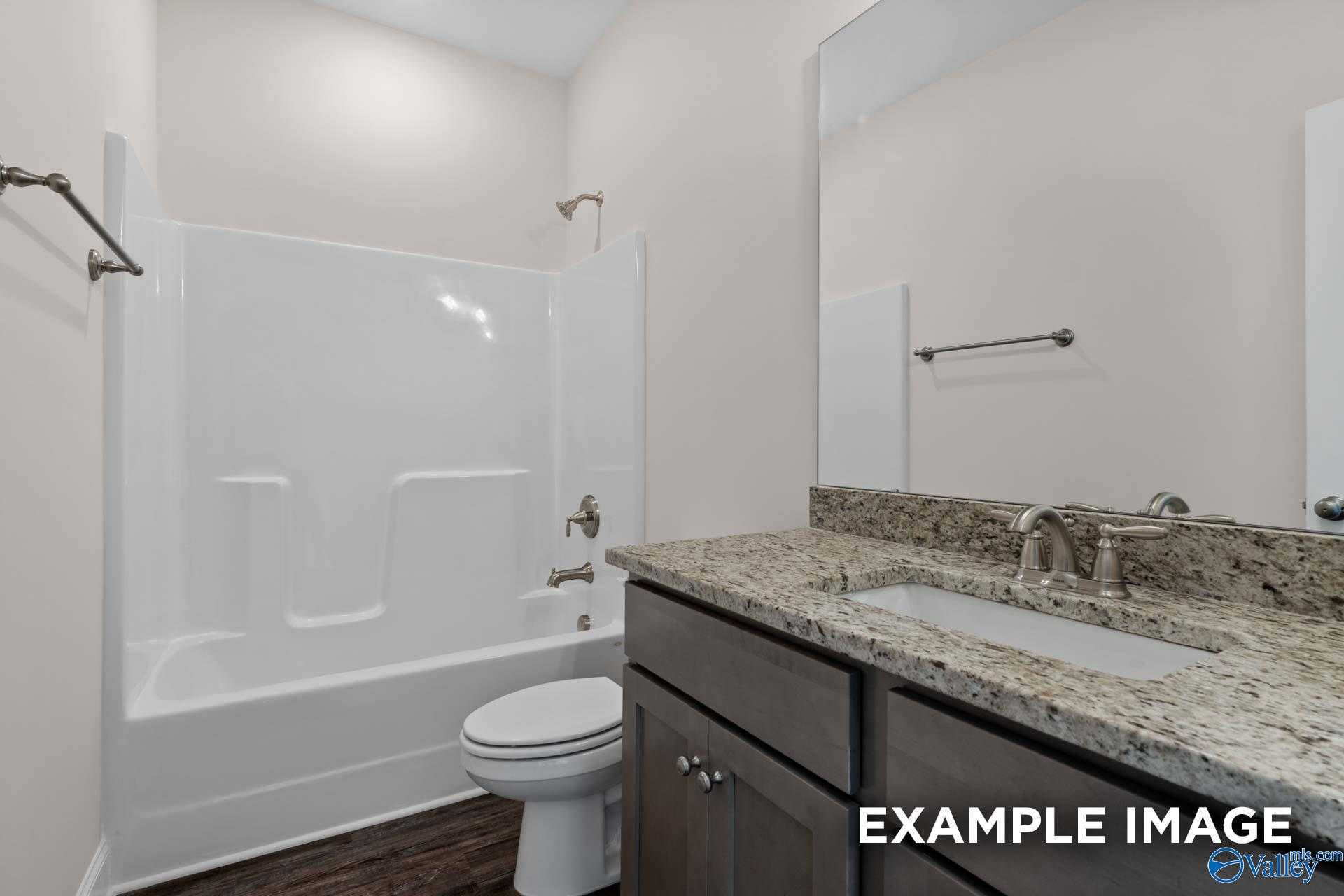 Bright bathroom with tub-shower combo, granite countertop vanity, and wood floors in Davidson Homes The Asheville, Arab, Alabama
