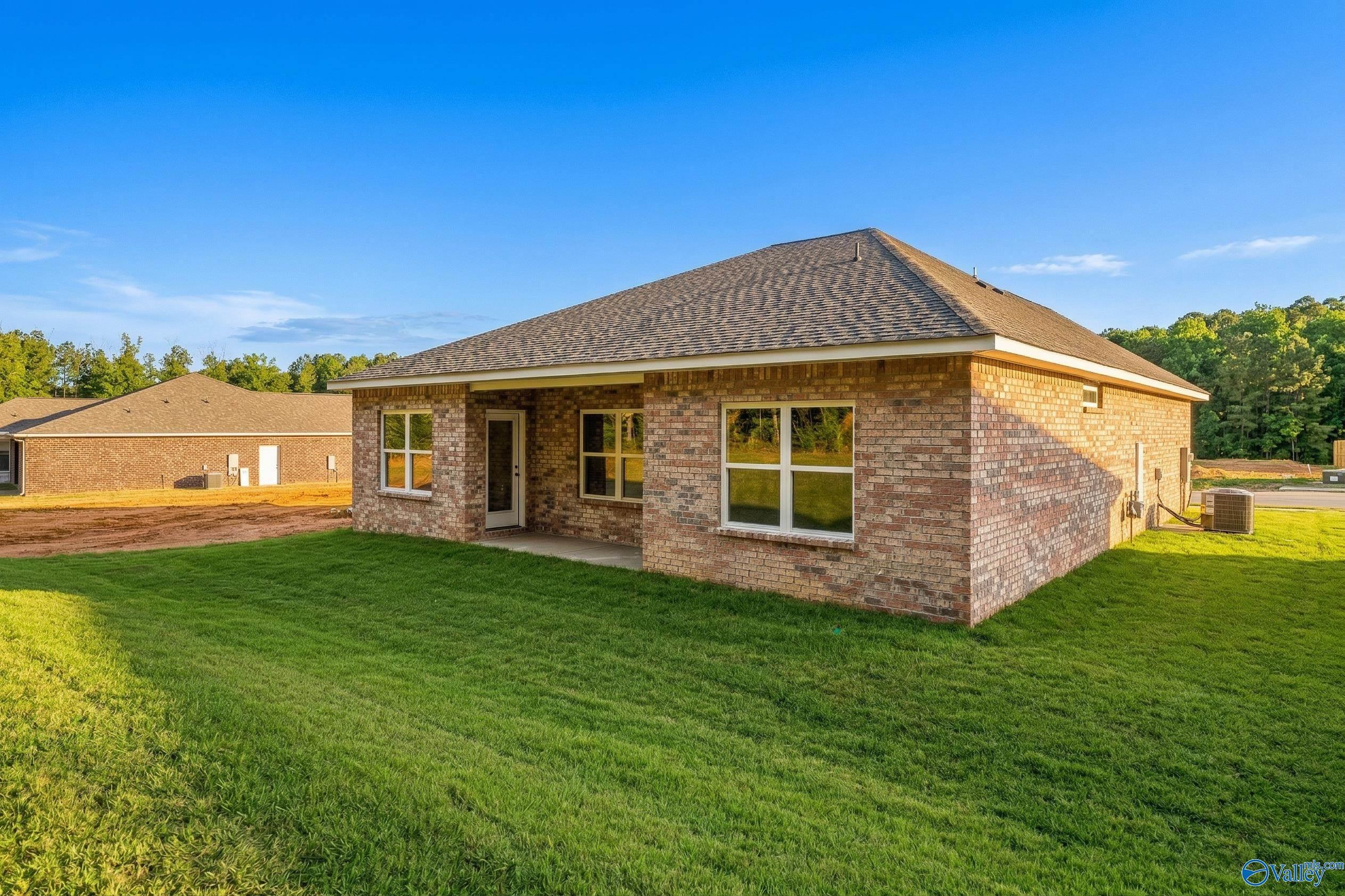 Brick exterior and backyard of The Asheville C floor plan by Davidson Homes in The Highlands, Arab, Alabama.
