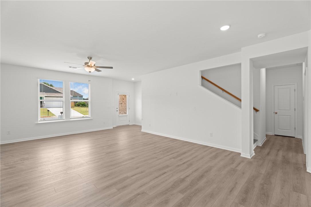 Bright, open-concept living area with wood-style flooring in The Stella D floor plan at Silver Oak in Cusseta, Alabama.
