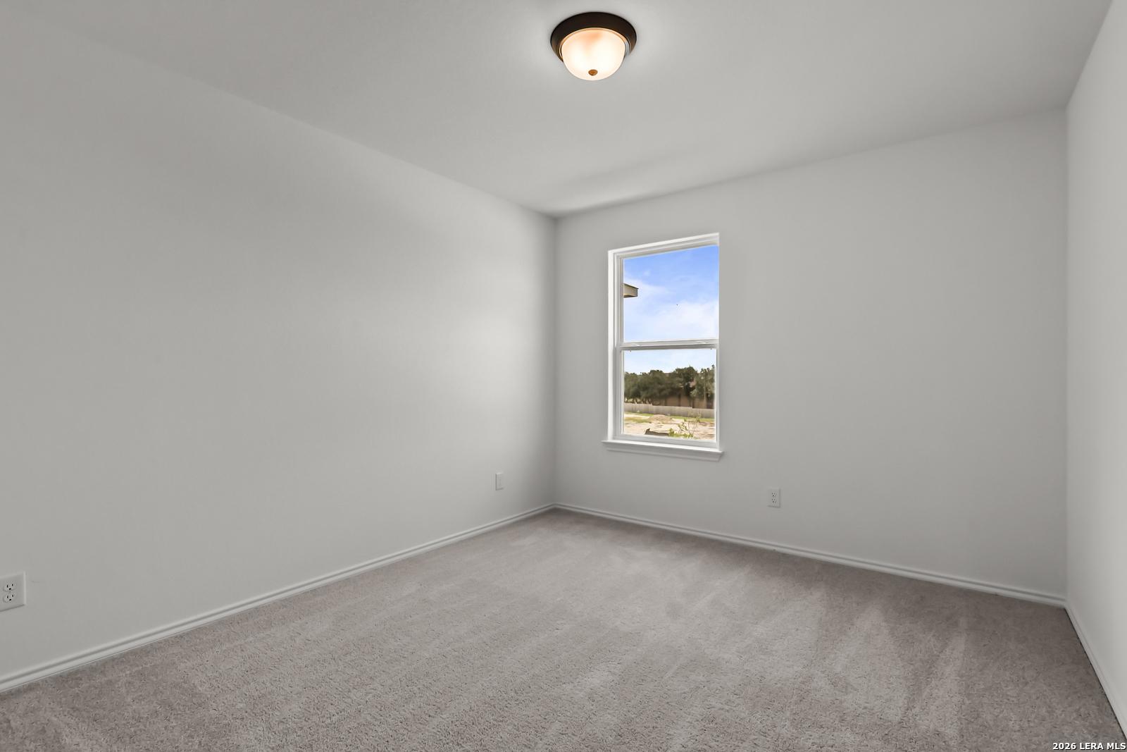 Bright secondary bedroom with plush carpet and natural light in The Florence B floor plan at Meadows at Oak Creek.