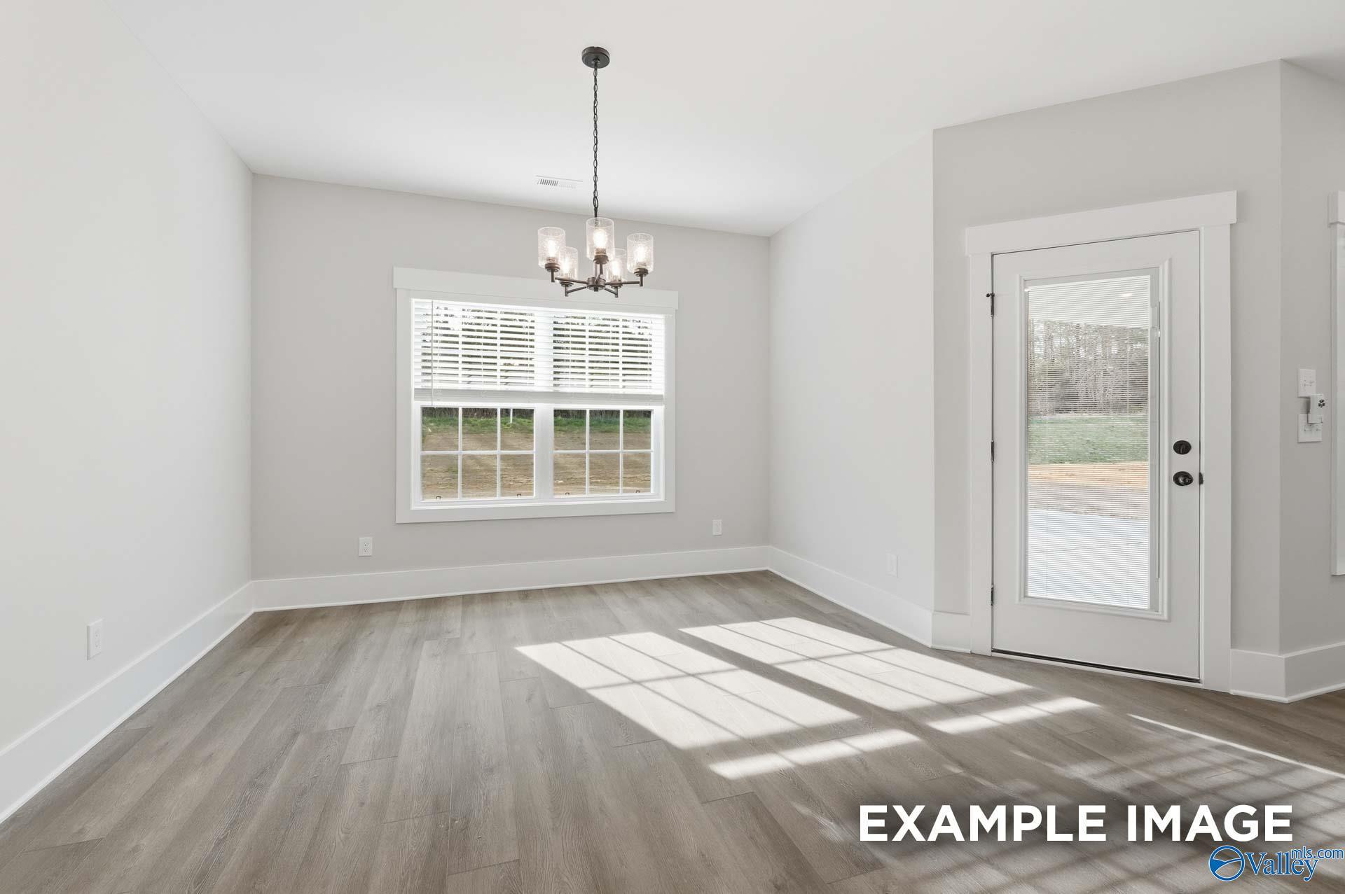 Bright dining area with modern chandelier and wood-look flooring in The Rockford floor plan, Briercreek in Meridianville.