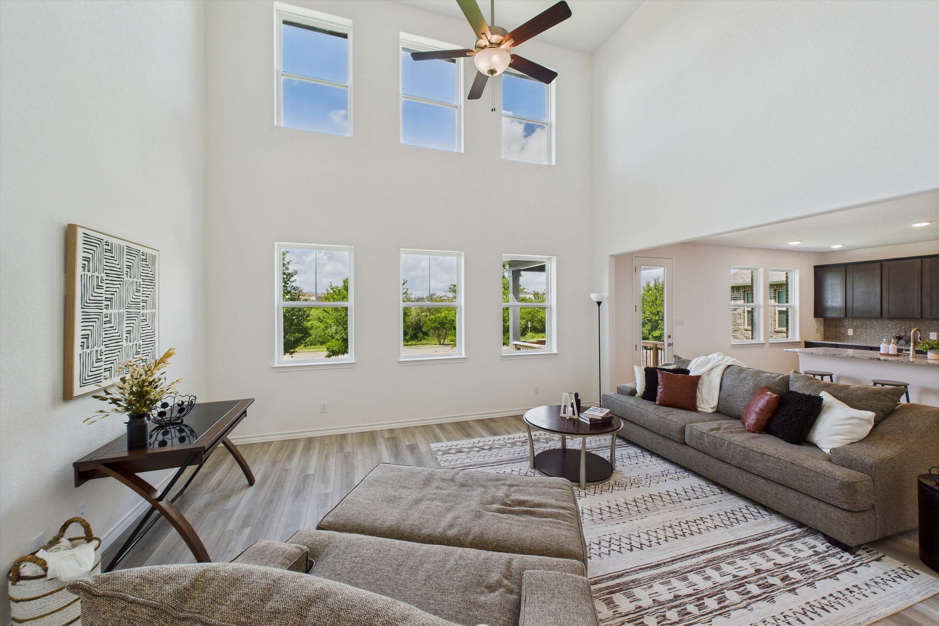 Spacious two-story living area in The Danbury with soaring vaulted ceilings, large windows, and open-concept floor plan.