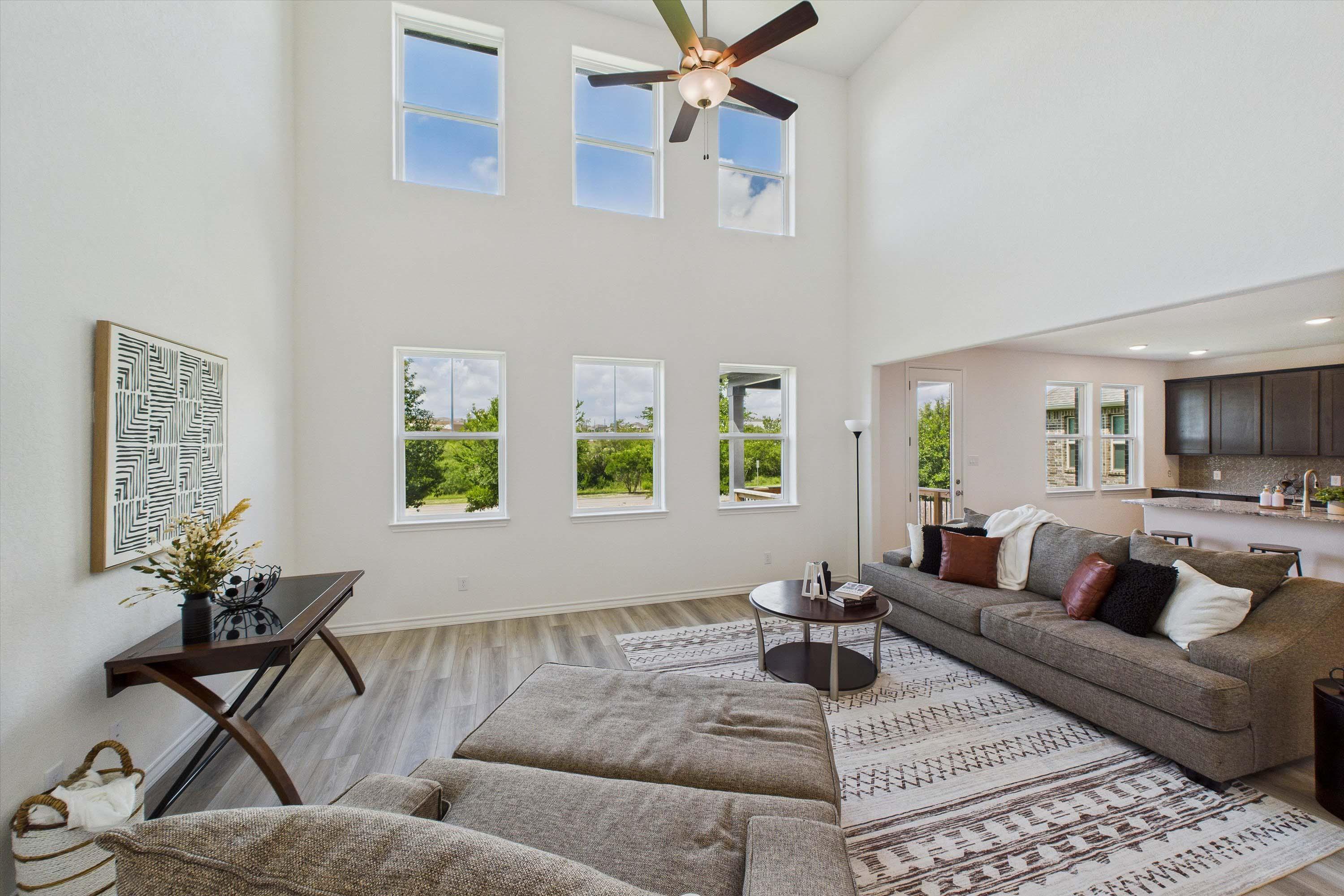 Spacious two-story living area in The Danbury with soaring vaulted ceilings, large windows, and open-concept floor plan.