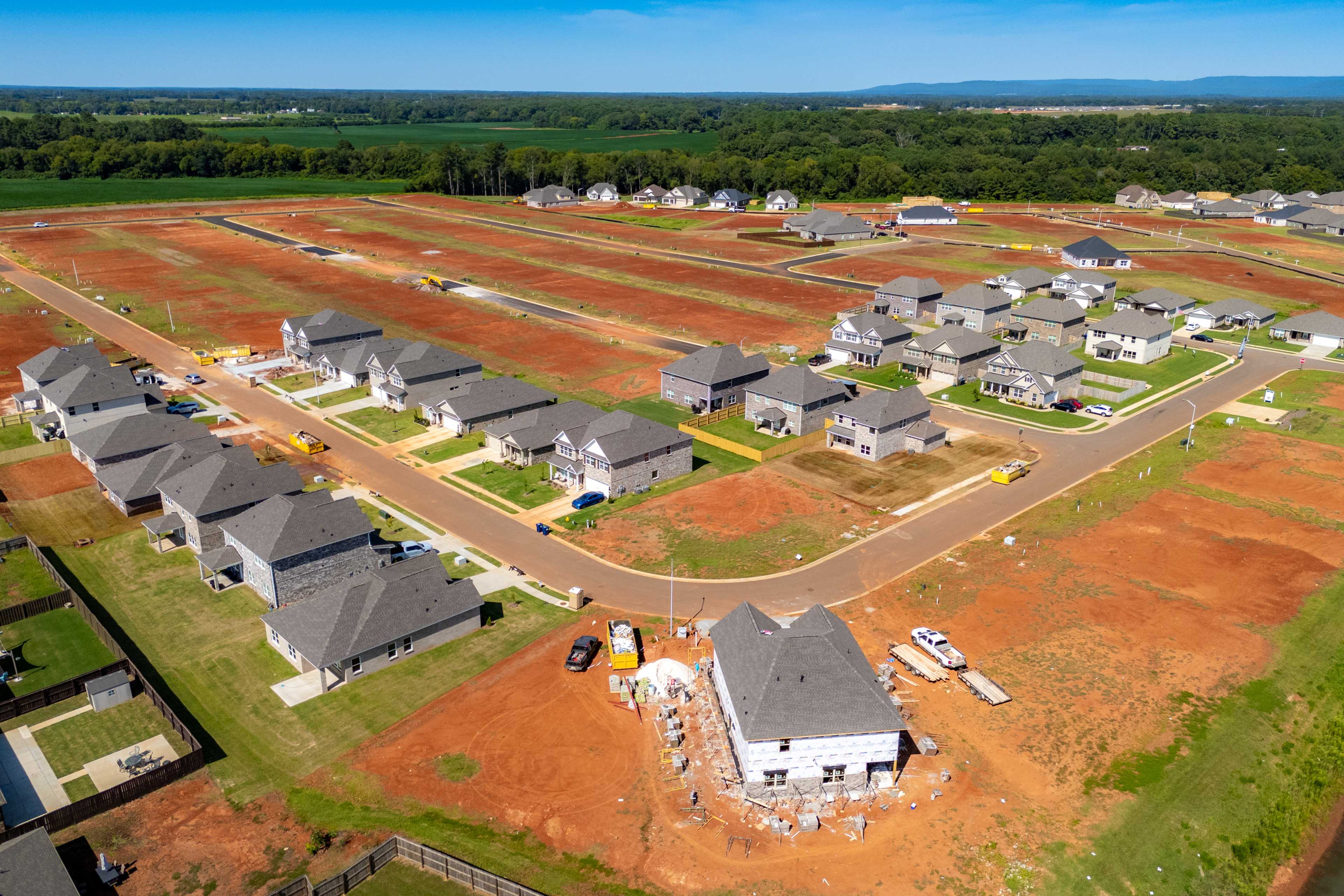 Aerial view of new gray-sided homes and red clay lots in developing Walker's Hill neighborhood, Meridianville Alabama