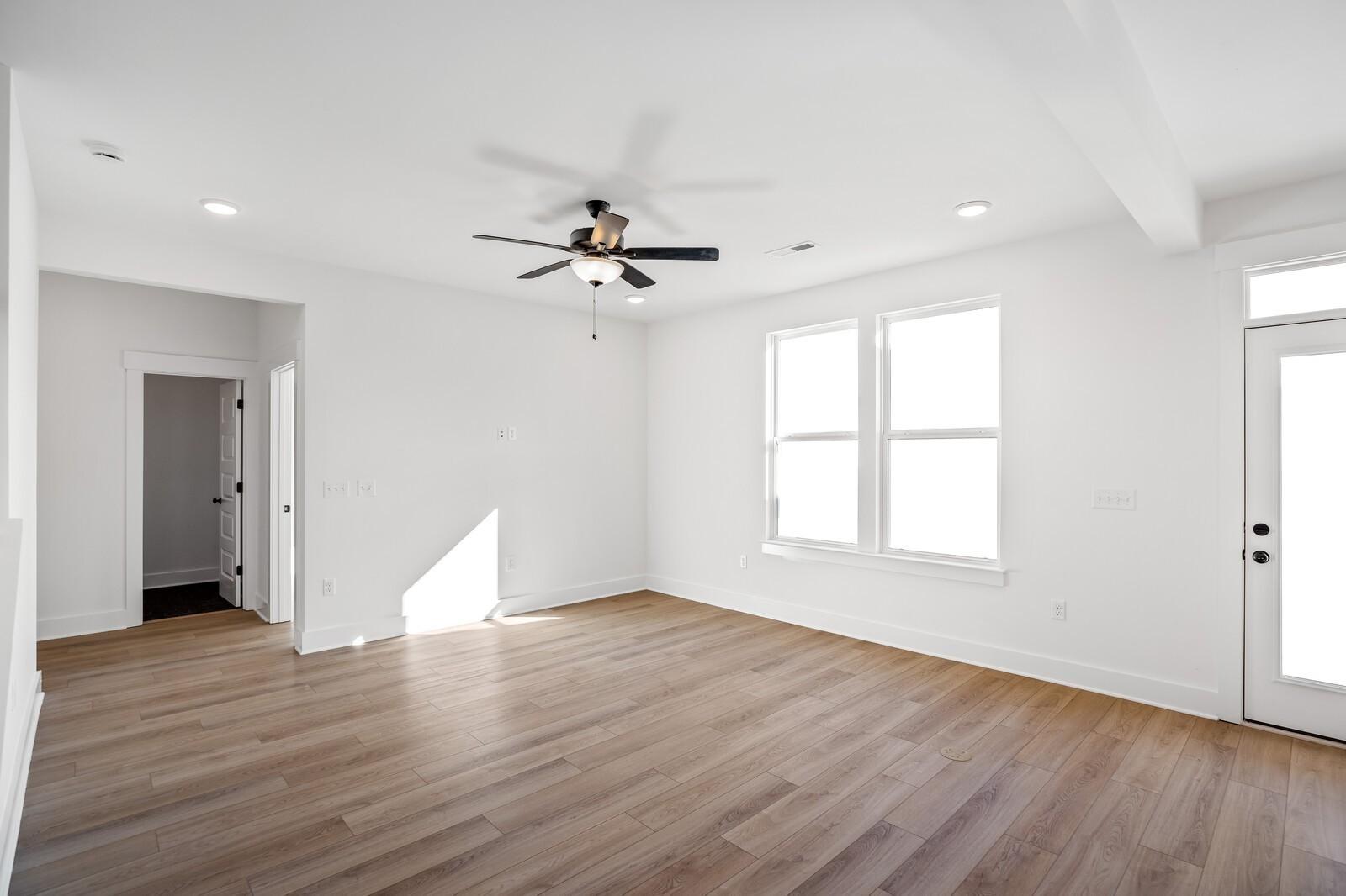 Bright family room with hardwood floors, ceiling fan, large windows, and French doors in Davidson Homes The Willow C, Gallatin, TN
