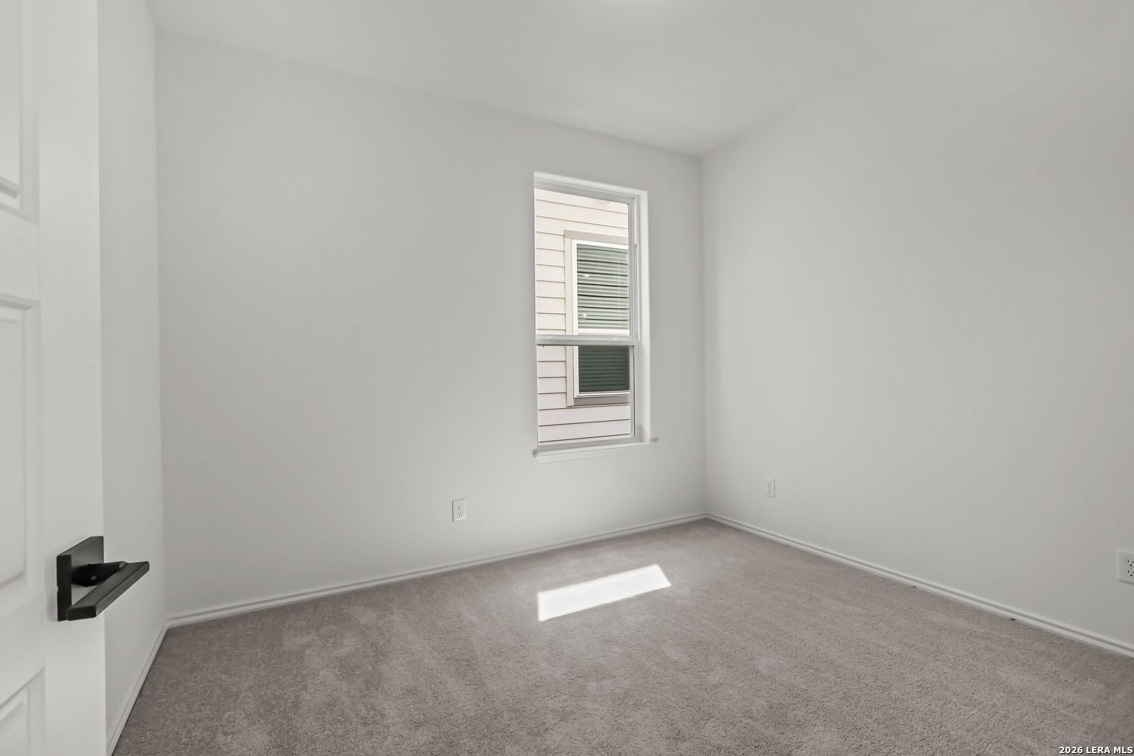 Bright, neutral-colored secondary bedroom in The Florence B floor plan at Meadows at Oak Creek, San Antonio, Texas.