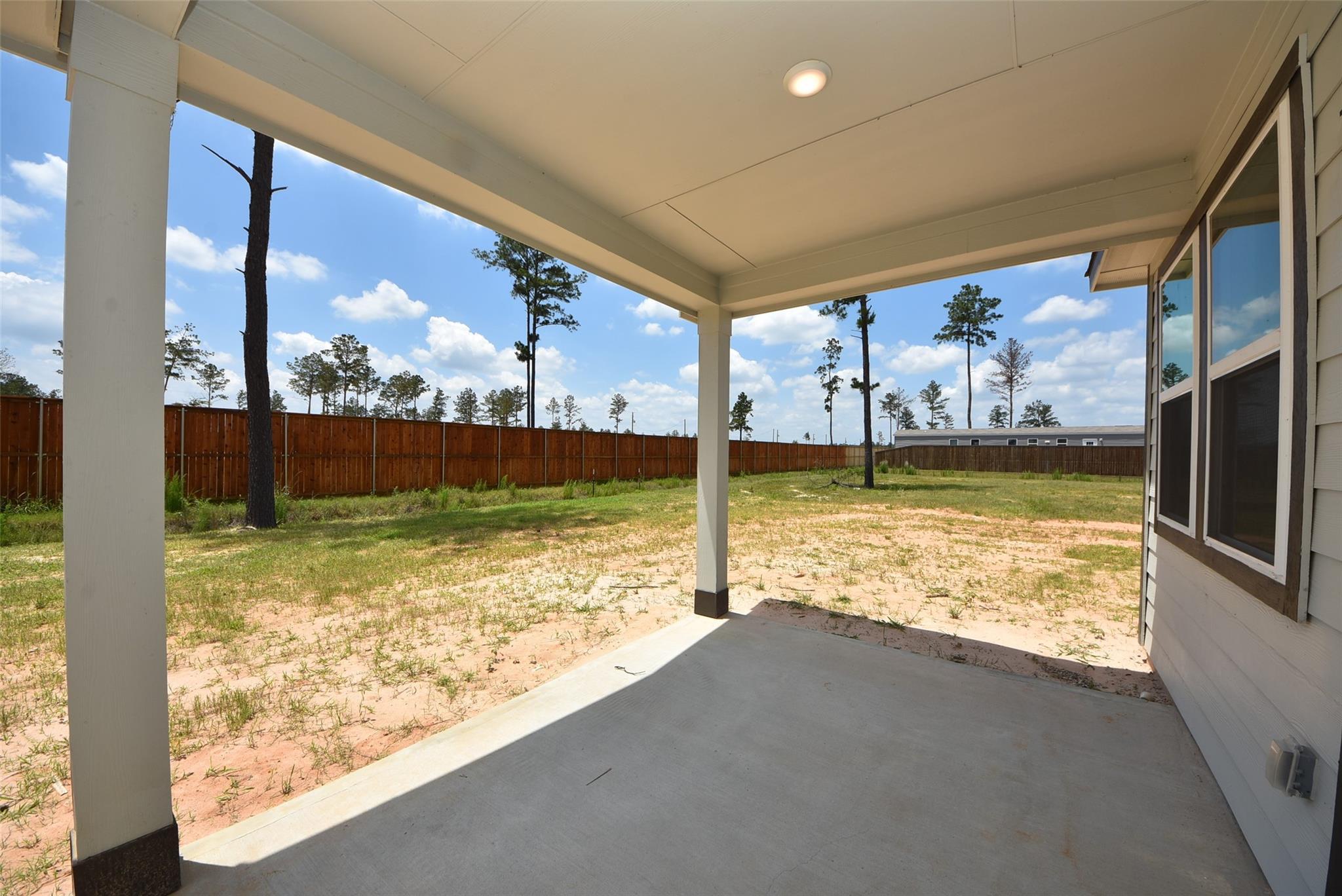 Covered back patio and spacious backyard at The Blanco F floor plan in Spring Branch Crossing, Conroe, Texas.