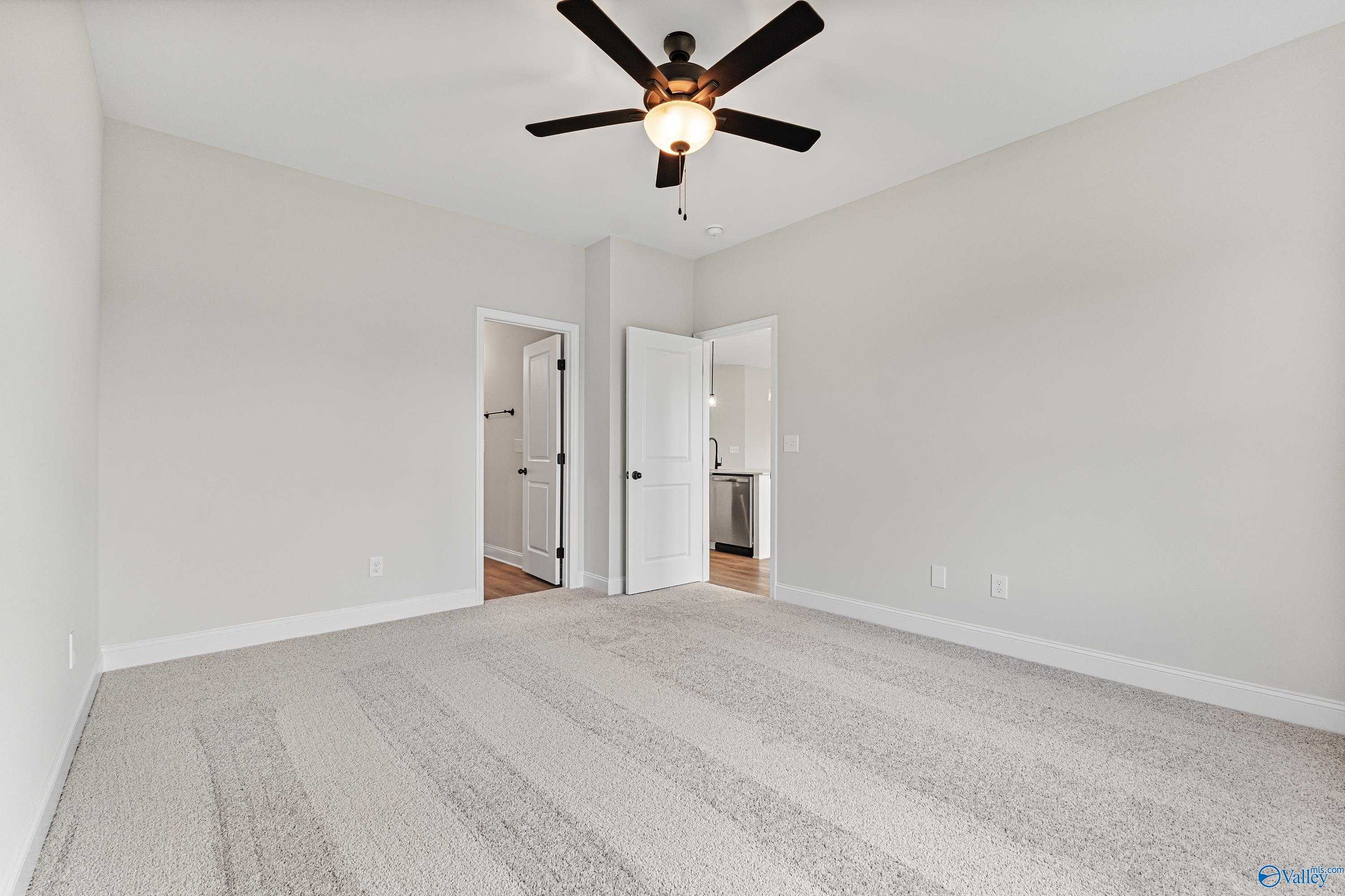 Spacious master bedroom with dual ceiling fans, en-suite bath, and walk-in closet in Davidson Homes The Franklin B, Hazel Green, AL