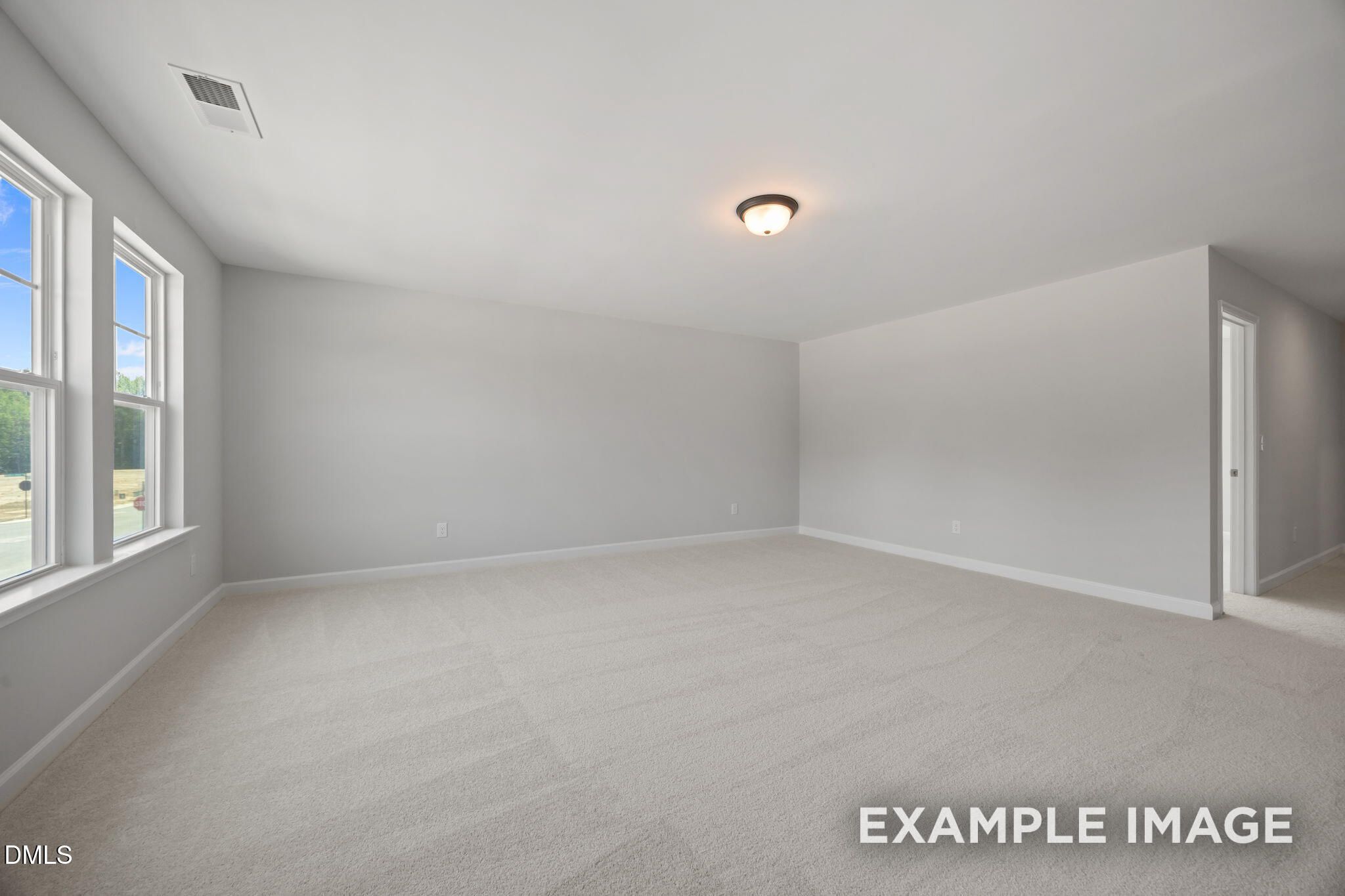 Spacious carpeted bedroom with natural light and neutral walls in Davidson Homes The Beech floor plan at Wendell Ridge, North Carolina
