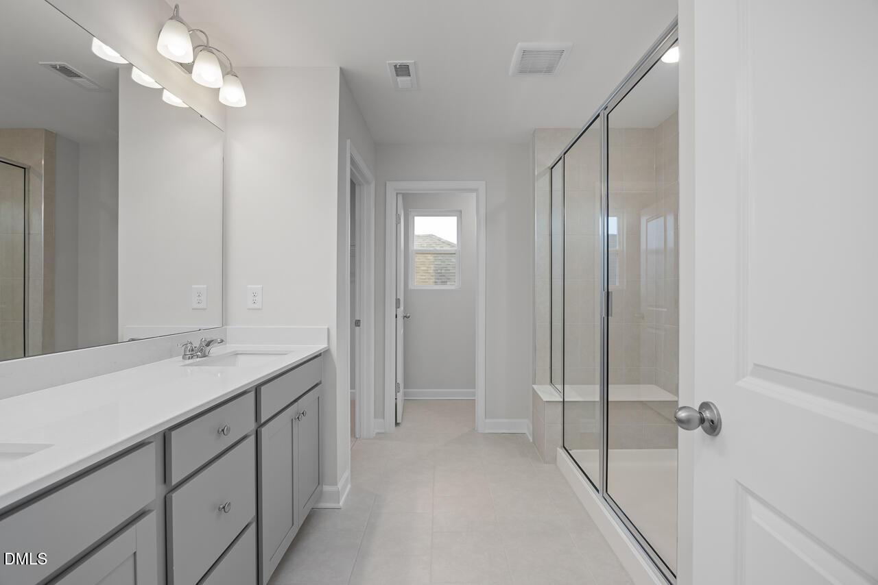 Modern master bathroom with double vanity, frameless glass shower in Davidson Homes The Gavin B, Lillington, NC