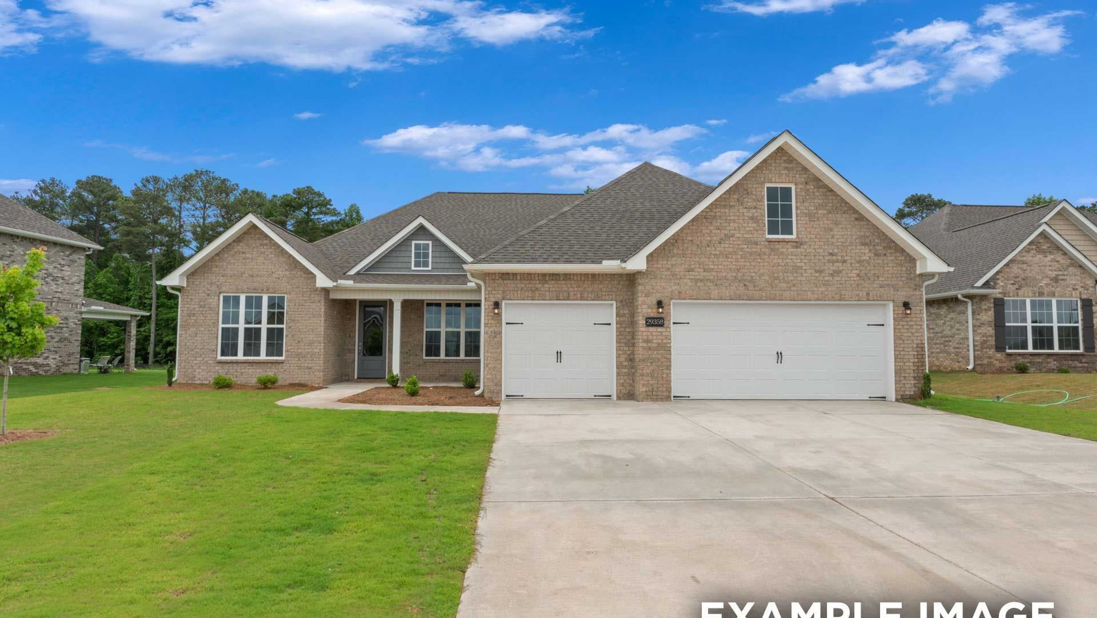 Modern brick ranch home at 16344 Sunfish Lane open house, Davidson Homes community, with two-car garage, lush green lawn, and pine trees under blue sky