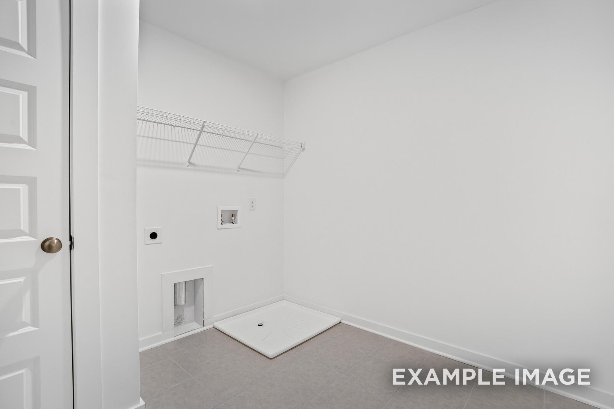 Bright laundry room in The Logan C featuring wire shelving, washer dryer hookups, and utility sink