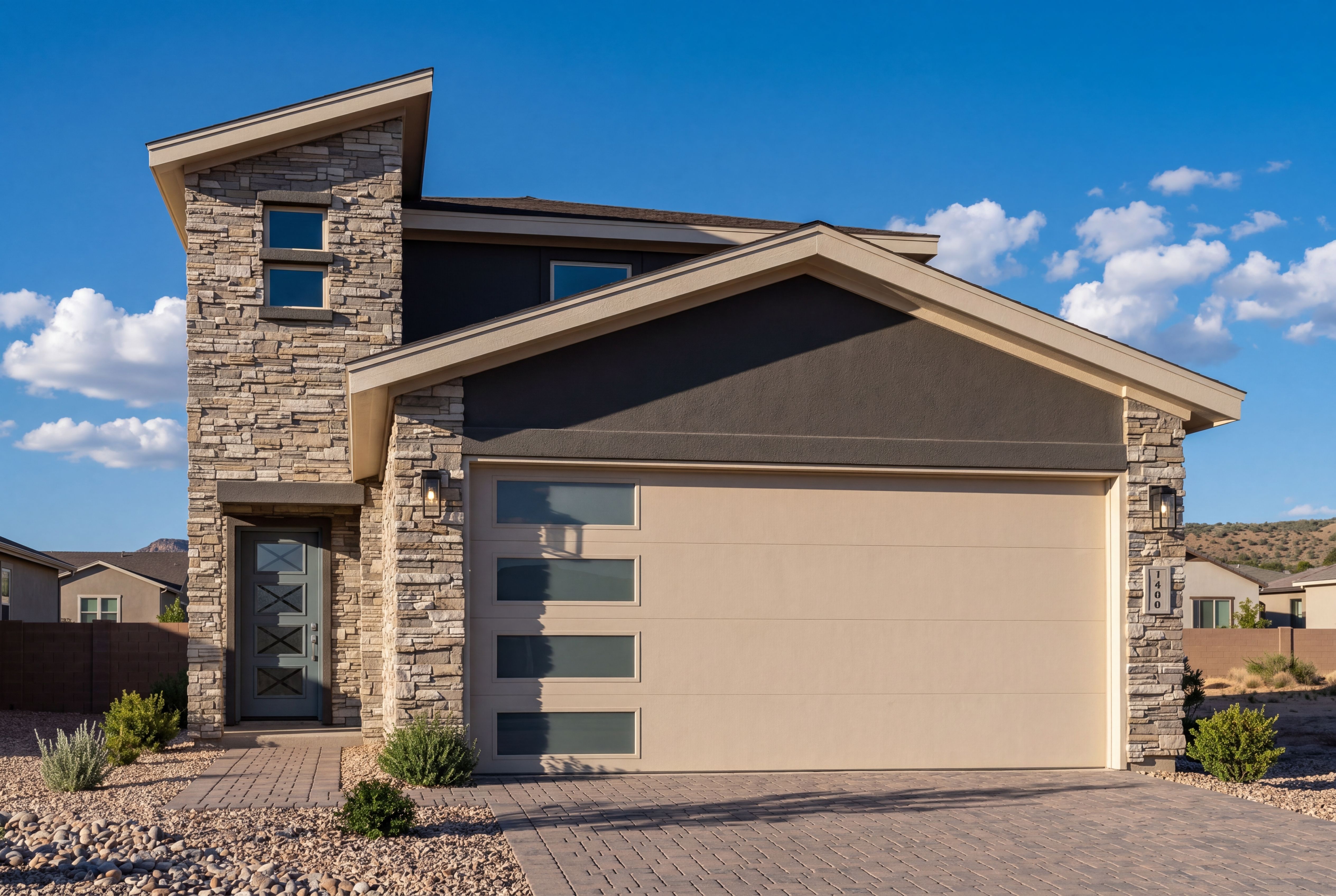 Modern exterior elevation of The Raleigh C in Prescott featuring stacked stone accents and a contemporary garage door.