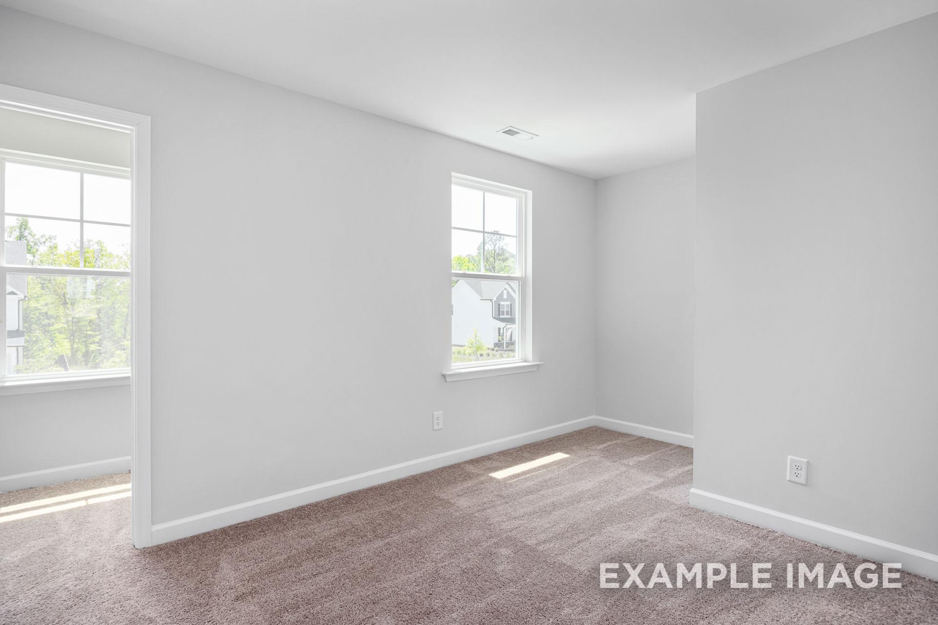 Bright secondary bedroom in The Gavin B with light gray walls, beige carpet, large windows, and natural light