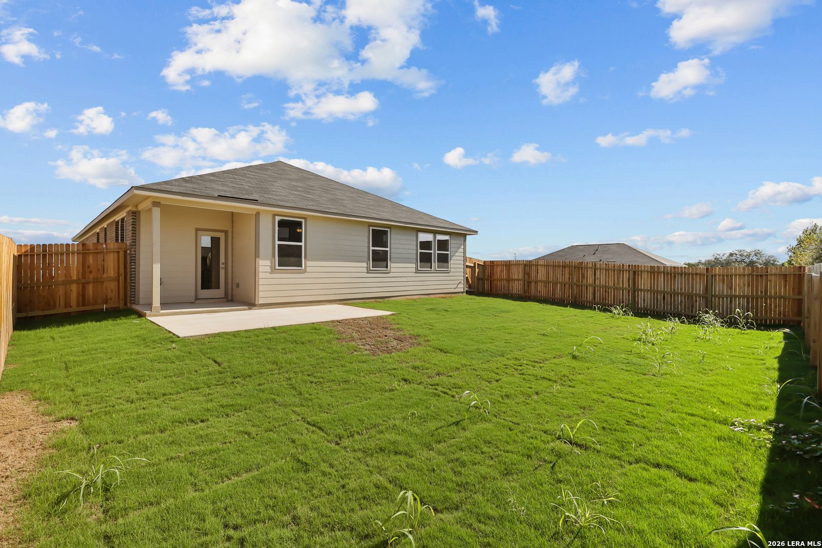 Back exterior with covered patio and fenced backyard of Davidson Homes The Daphne I in Bricewood, San Antonio, Texas