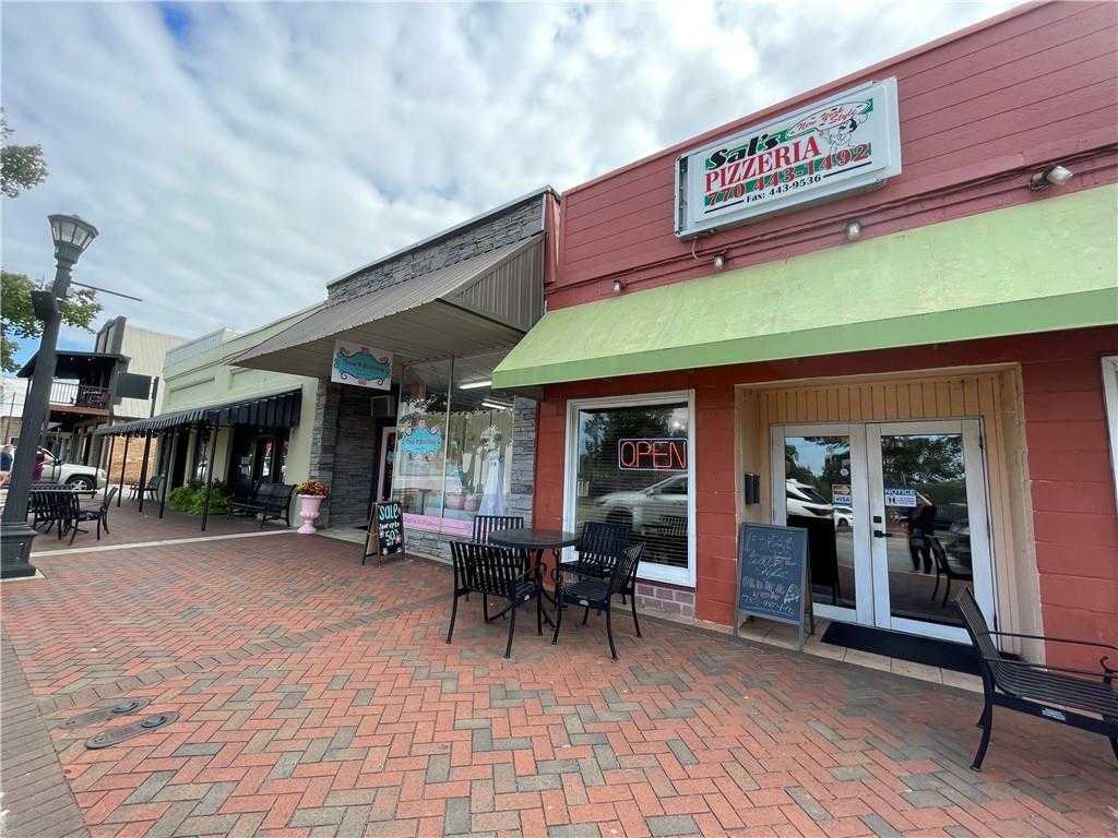 Sal's Pizzeria exterior in Dallas, Georgia with green awning, outdoor bistro seating on brick patio and quaint street vibe