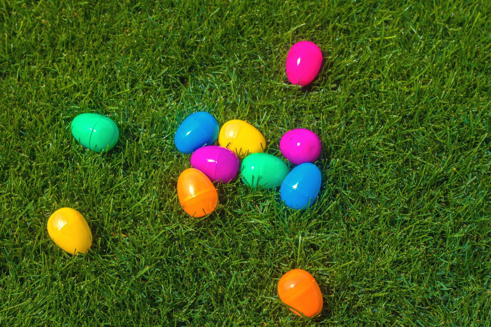 Colorful plastic Easter eggs scattered on lush green grass at Cain Park Easter Egg Hunt, Huntsville Region event by Davidson Homes