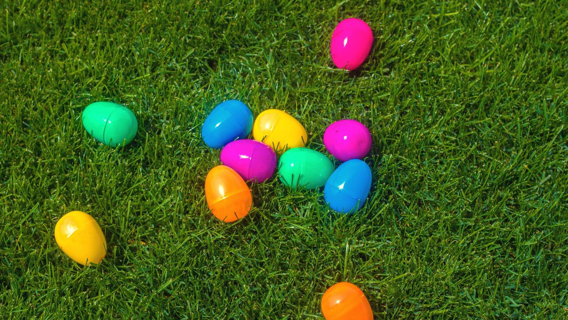 Colorful plastic Easter eggs scattered on lush green grass at Cain Park Easter Egg Hunt, Huntsville Region event by Davidson Homes