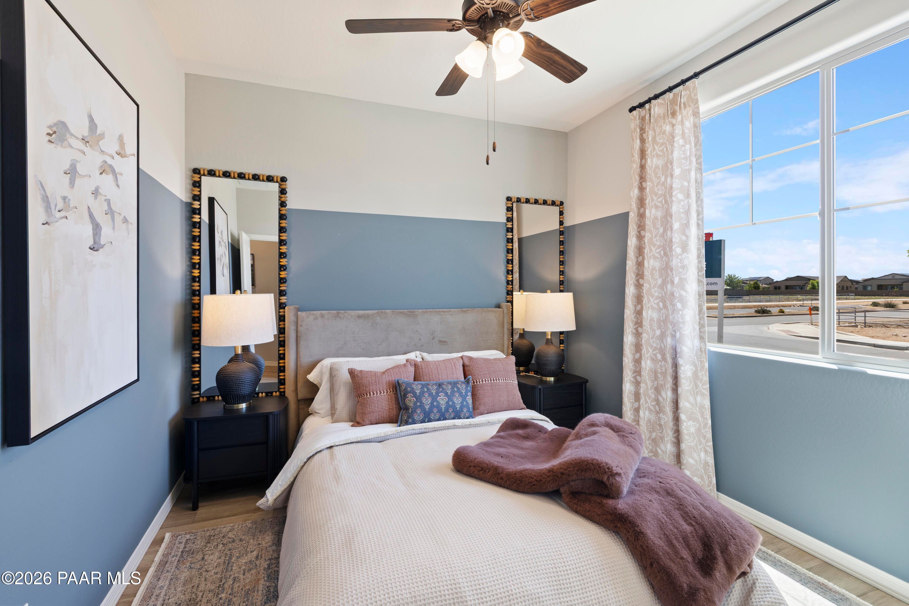 Cozy guest bedroom with blue accent walls and stylish decor in The Harmony A floor plan at Pronghorn Ranch, Prescott Valley.