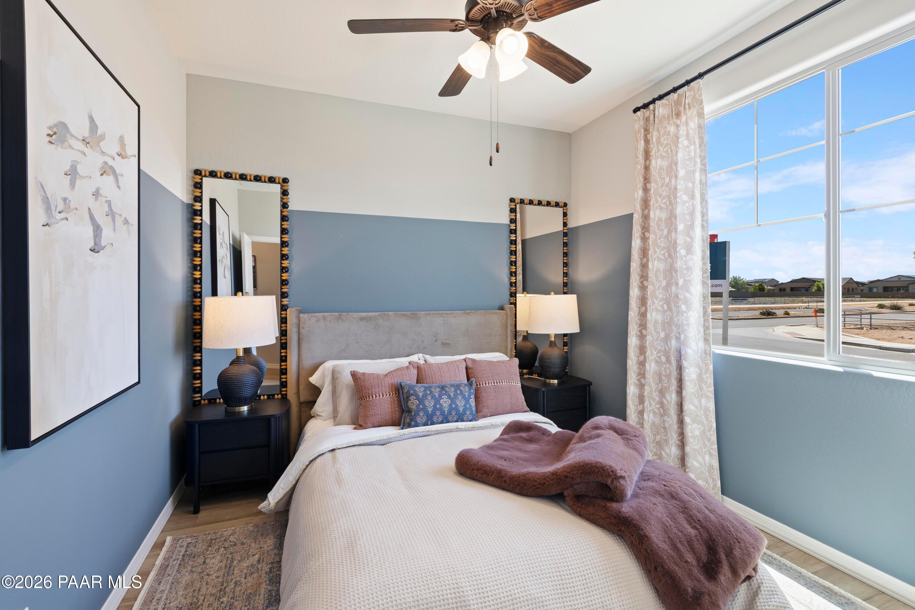 Cozy guest bedroom with blue accent walls and stylish decor in The Harmony A floor plan at Pronghorn Ranch, Prescott Valley.