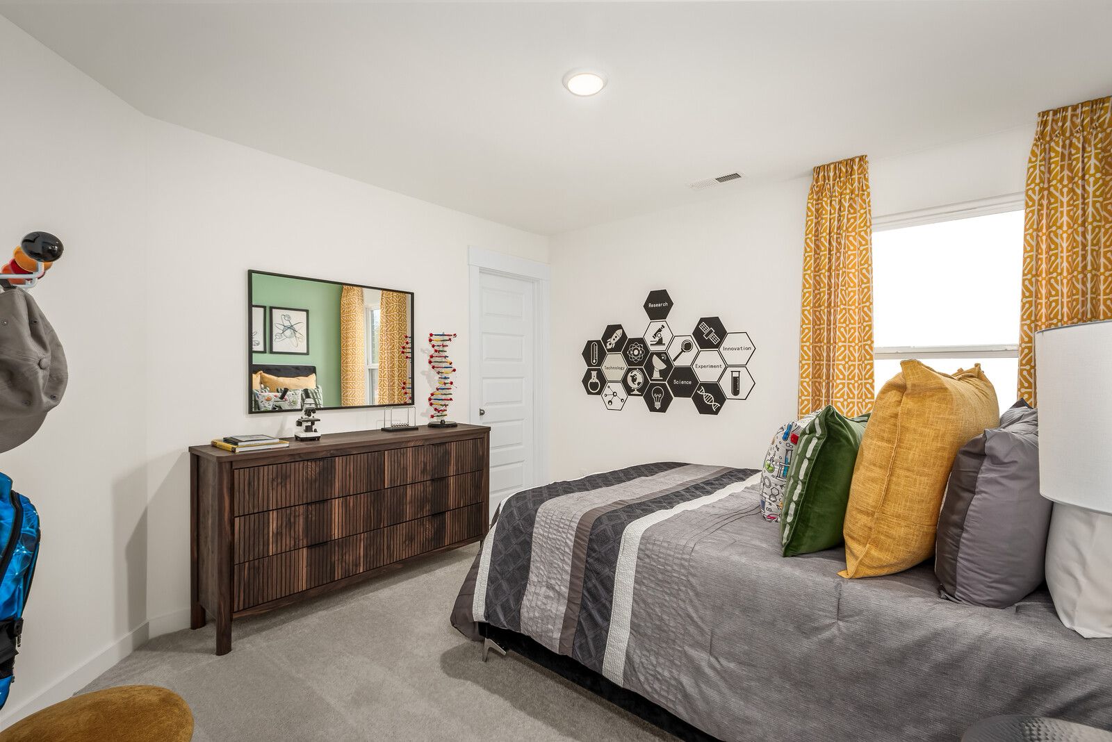 Cozy bedroom at Benders Cove in Mt. Juliet, Tennessee with gray bed, wooden dresser, yellow curtains, and geometric art