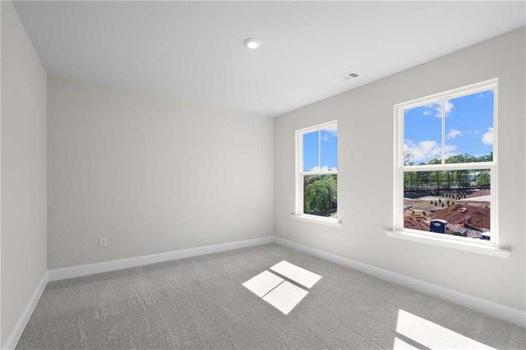 Bright empty bedroom with large windows and natural light in Davidson Homes The Hickory B, Buford, Georgia